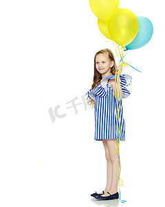 可爱的金发小女孩穿着很短的夏季条纹连衣裙。