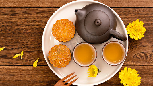 深色木桌上有茶的月饼，中秋节传统食品布局设计的节日概念，顶视图，平躺，复制空间。