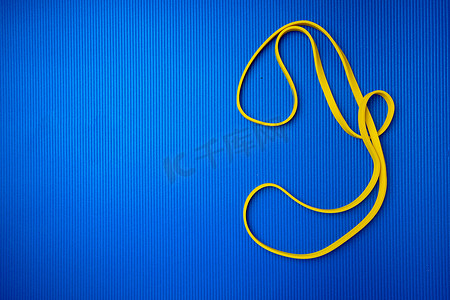 健身跳摄影照片_蓝色垫子背景上的黄色健身绳