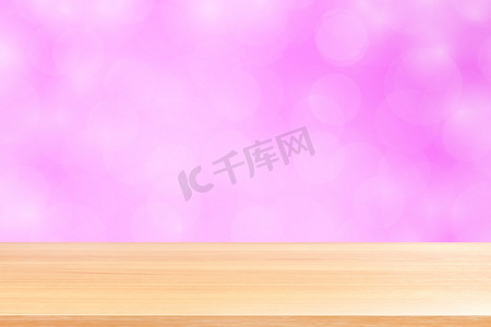 粉红渐变摄影照片_模糊的散景软粉色渐变背景上的空木桌地板，粉红色散景彩色浅色上空的木板，彩色散景灯渐变软用于横幅广告产品