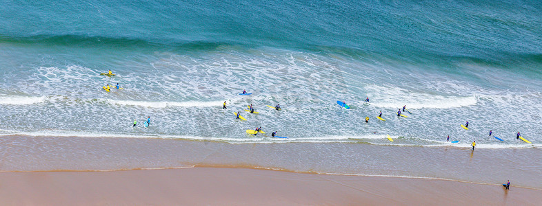 英国康沃尔郡莫根波思海滩附近海浪中的冲浪者