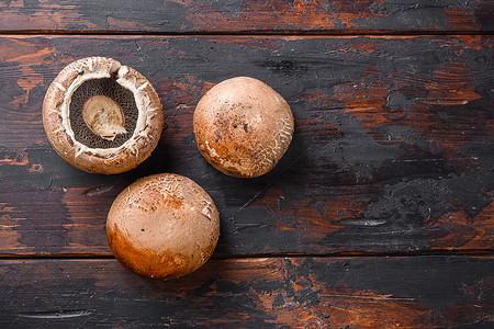 成熟的 portobello 蘑菇设置在深色旧木桌面视图空间的文本。
