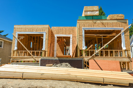 正在建设中的新家庭住宅，顶部有成堆的 2x4 木板