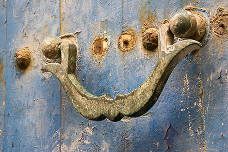 门上古老生锈的门环，蓝色褪色油漆