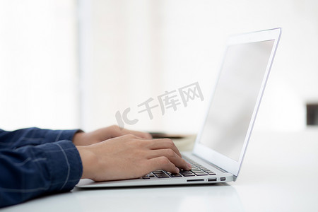 在家工作的商人之手，使用笔记本电脑在办公桌上上网，新常态的生活方式，社交距离，自由职业者在家工作，员工在室内使用笔记本电脑。