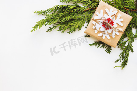 圣诞节和新年背景与崖柏分支和礼物包裹在牛皮纸与雪花。