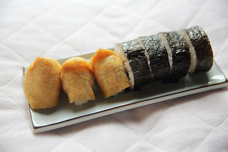 豆腐摄影照片_调味米饭裹在炸豆腐袋中，日本稻荷寿司