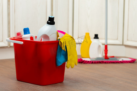 盖住水桶摄影照片_地板上塑料桶中的各种家用清洁剂和瓶子