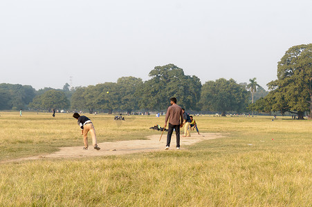 2019年5月，亚洲印度西孟加拉邦加尔各答欢乐城伊甸花园体育场附近的冬日日落傍晚，当地印度男孩在迈丹地区玩板球比赛