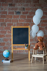 成堆玩具摄影照片_回到学校概念：粉笔板、成堆的书、地球仪和泰迪熊