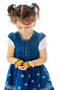 小女孩手里拿着一只大蝴蝶。