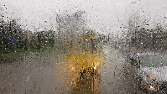 秋天窗户摄影照片_秋天汽车后窗下雨。