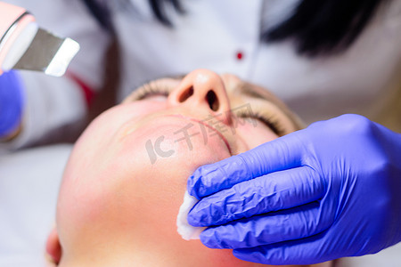 美容师使用带有微振动的超声波来滋润面部和去除角质化的旧皮肤。