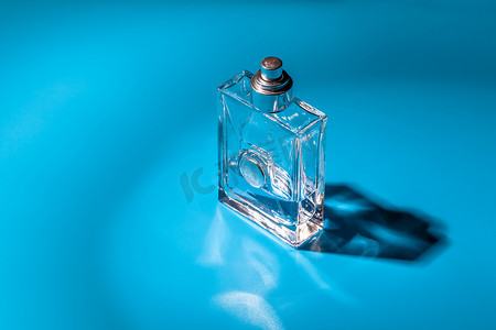 淡蓝色背景上的香水玻璃瓶。