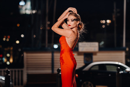 夜城马赛街头，一个穿着红色晚礼服的优雅女孩。法国一个穿着红色晚礼服的女人