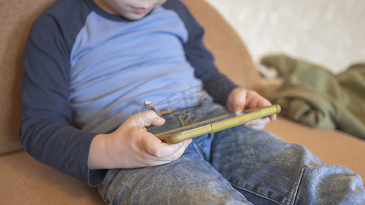 手机app搜索框摄影照片_小男孩在家玩手机或学习