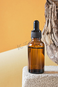 棕色玻璃瓶，在木质浮木背景、棕色背景的混凝土讲台上放着吸管