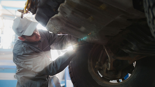 车库汽车服务 — 机械师操作车轮，背光