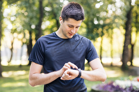 使用智能手表点击触摸屏的成年男子享受健康积极的生活方式。
