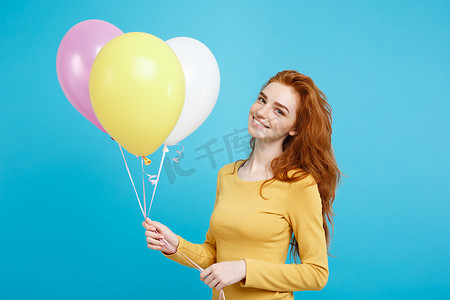 生日庆祝背景摄影照片_庆祝概念-特写肖像快乐年轻美丽迷人的红发女孩微笑着五颜六色的派对气球。
