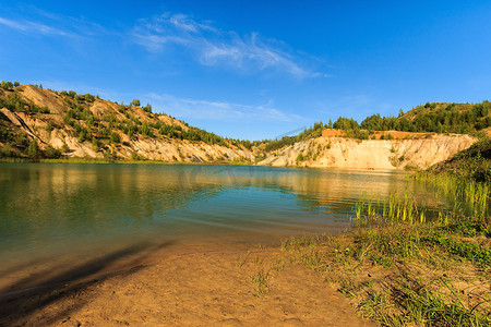 png绿水摄影照片_有沙滩、绿水、树木和蓝天的山丘的采石场或湖泊或池塘