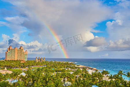 棕榈树覆盖的岛屿度假村上方加勒比海的彩虹