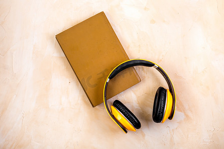 耳机和书籍相连 — 米色桌子上自上而下的有声读物概念