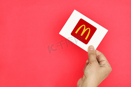 手拿着一张带有麦当劳标志的卡片