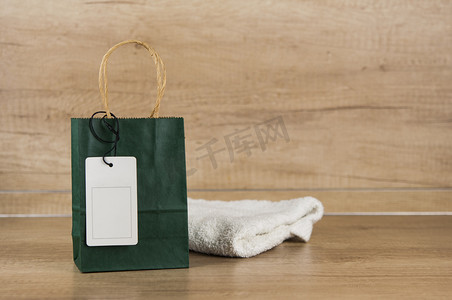 木桌上贴着木墙的带空白标签的购物袋