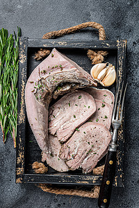 红烧小羊肉摄影照片_煮熟的煮小牛肉或牛舌切成木盘。