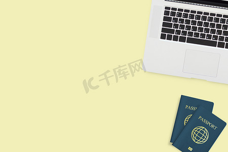 两台护照电脑笔记本电脑平铺在柔和的黄色背景上，带有复制空间。