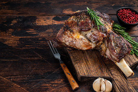 羊腿肉摄影照片_在木菜板上烤羊肉羊腿肉。