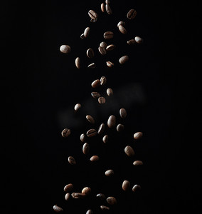 黑色背景中飞行的烘焙咖啡粒