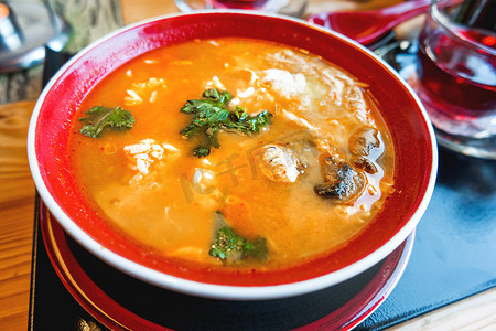亚洲美食 — Tom kha kai 或泰国椰子汤，配鸡肉、米饭、蘑菇、生姜和柠檬草，装在红碗里。