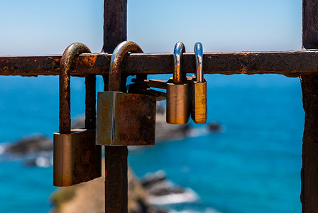 海边栏杆上挂着生锈的挂锁，这是表达爱意的传统方式