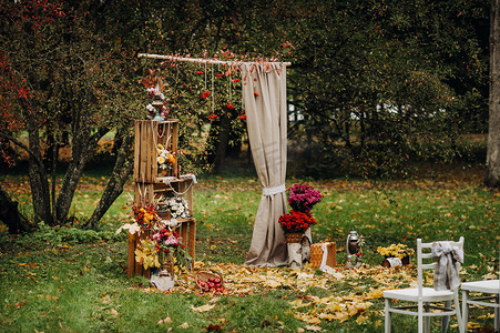 秋季婚礼在绿色草坪的街道上举行。仪式上装饰着鲜花拱门
