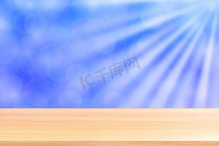 空木桌地板上柔和的蓝色散景灯光束闪耀渐变背景，木板空在蓝色散景彩色灯光上，彩色散景灯渐变软用于横幅广告