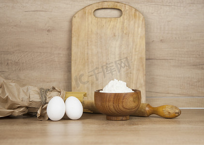 木桌上的意大利面面团，配有鸡蛋、面粉和擀面杖