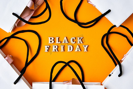 木字文字“黑色星期五”，前面有黄色背景的包装袋、复制空间、横幅顶视图平躺季节性销售、零售、购物概念
