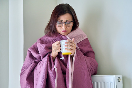 成年女性用毯子、暖气片、热茶取暖