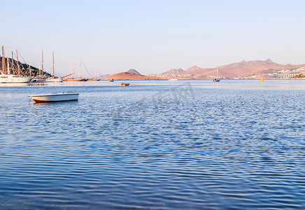 在爱琴海的美好的日出与海岛、山和小船