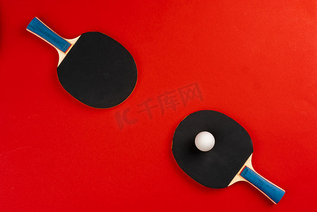 游戏手柄摄影照片_红色背景中的黑色乒乓球拍