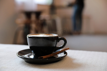 白色织物背景上的卡布奇诺咖啡杯