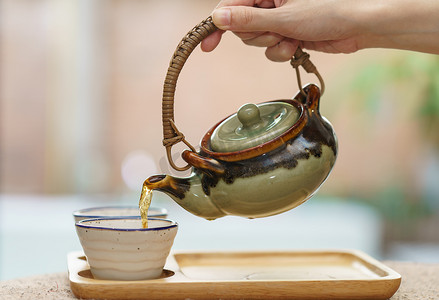 热茶从壶中倒入玻璃茶杯。