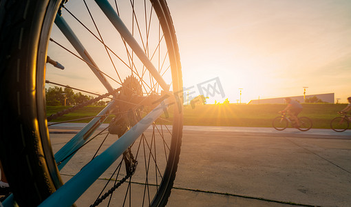 模糊的照片运动员在晚上与夕阳的天空在路上骑自行车以速度运动。