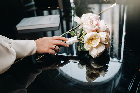 胸花新娘摄影照片_与玫瑰和胸花的婚礼花束。婚礼上的装饰