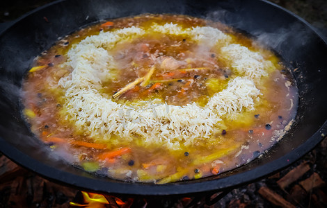 大铸铁锅中的米饭抓饭着火