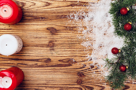 圣诞摄影照片_有雪和红色圣诞小玩意的木板