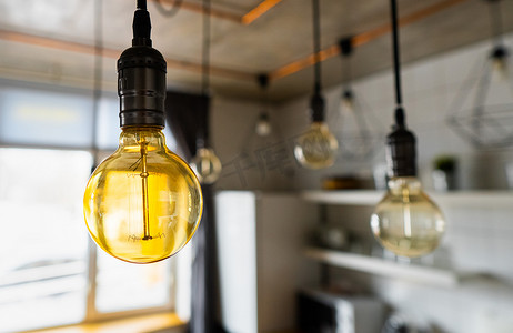 白炽灯充电摄影照片_挂在现代厨房里的大老式白炽灯泡。
