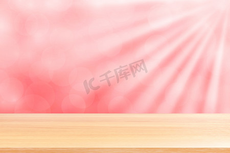 空木桌地板上柔和的粉红色散景灯光束闪耀渐变背景，木板空在粉红色散景彩色灯光上，粉红色彩色散景灯渐变软用于横幅广告